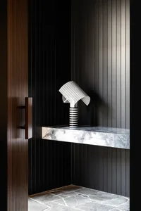 A minimalist entryway featuring a modern lamp and marble countertop
