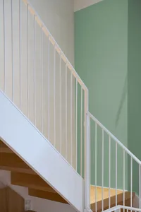 Modern staircase with wooden steps and white metal railings