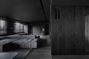 A modern minimalist living room with dark wood furniture and sleek, dark interior design.