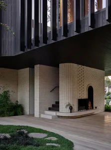 A modern exterior staircase with brick walls and steps, featuring a fireplace and seating area.