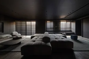 A modern living room with a large grey fabric couch, wooden coffee table, and dark wooden floor.