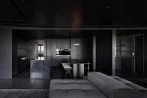 A modern kitchen with a sleek, minimalist design featuring a large marble island and dark wooden accents.