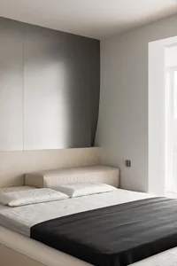 Modern minimalist bedroom with neutral color palette and simple design elements.