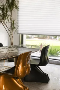 Contemporary dining room featuring metallic chairs and a marble table.