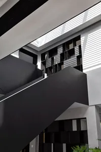 Modern interior design featuring matte black stairs and geometric concrete wall