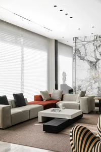 Modern living room with concrete walls, contemporary sofa set, and minimalist decor.