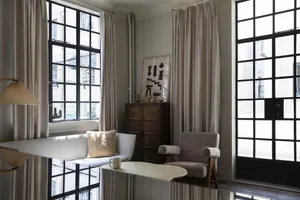 Modern living room featuring fabric furniture, wood accents, and glass windows with a minimalist decor.