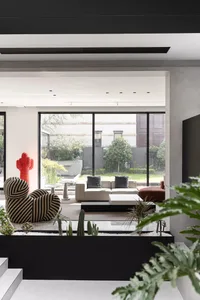 Modern living room interior with glass walls displaying cactus plants.