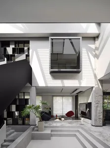 A modern minimalist interior design with concrete features and a mix of black and white materials.