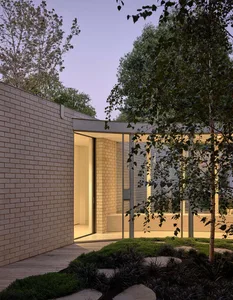 Modern residential exterior with brick, glass, and concrete materials
