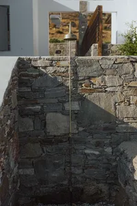 Outdoor shower with stone wall and shower head spraying water