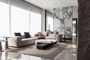 A modern living room with marble accents and leather furniture.