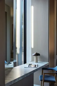 A modern office space featuring a minimalist marble countertop with a sleek table lamp.