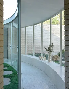 A modern interior featuring white brick walls and concrete flooring.
