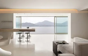 Modern minimalist living room with concrete flooring, minimalist furniture, and large windows overlooking mountains.