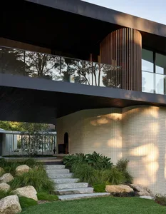 Modern residential building with exterior features including brick, glass, and wood elements.