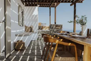 Industrial-style wine bar with ocean view seating and wooden furniture.