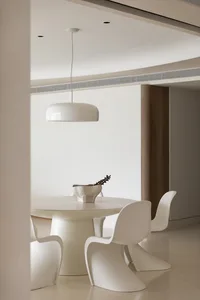 Modern dining room with white furniture and a minimalist design aesthetic.
