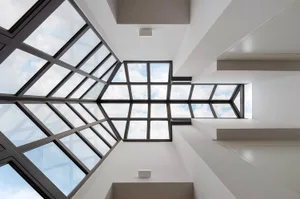 A modern interior design featuring a glass ceiling with geometric patterns and a bright, open space.