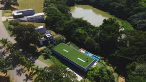 A modern residential exterior with greenery and a swimming pool.