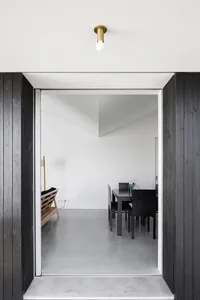 Modern, interior design featuring a room with concrete flooring and minimalist furniture.