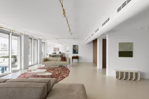 A modern living room with concrete and marble flooring.