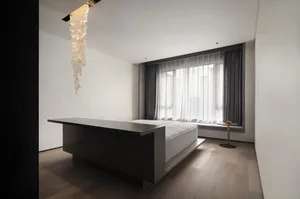Modern minimalist bedroom featuring a concrete bed platform, large window with curtains, and a glass chandelier.