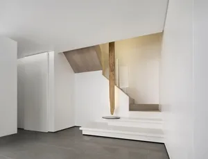 Modern, minimalist staircase with white walls and wooden accents.