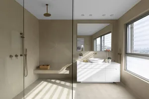 Modern bathroom featuring sleek, minimalist design with tiled walls and floor.