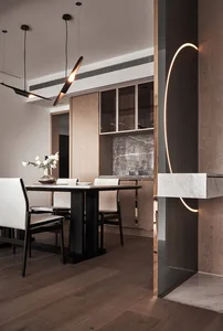Modern dining room with marble table, wooden chairs, and metal accents
