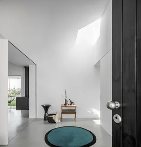 Modern entrance hallway featuring a concrete floor and minimalist design.