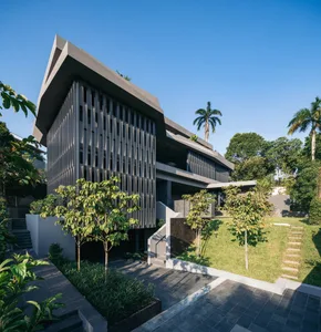 A modern house featuring metallic exterior walls and a sleek, triangular roof.