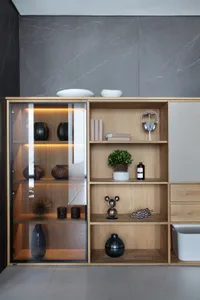 Modern interior design featuring a wooden entertainment center with various decorative items and lighting.