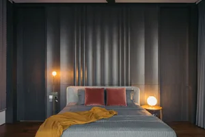 A contemporary bedroom featuring a bed with neutral-toned bedding and a minimalist design.