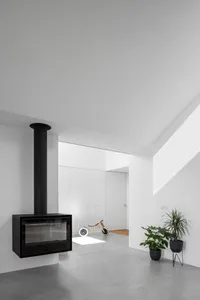 A minimalist interior design featuring concrete elements and a hanging fireplace.