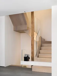 Modern minimalist staircase with wooden steps and glass railings.