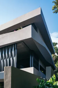 Exterior view of a modern residential building featuring a concrete façade and angular architectural design.