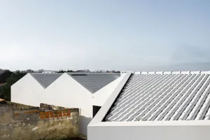 Modern building with white tiled roof in an outdoor setting.