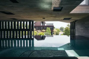 Indoor infinity pool with glass-tile and concrete elements.