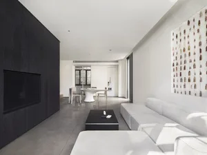 A minimalist living room with a concrete floor and leather sofa.
