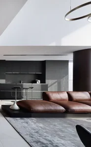 A minimalist living room featuring a brown leather sofa, metal stools, and glass cabinets.