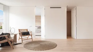 Minimalist living room featuring wooden furniture, textile accents, and a jute rug.