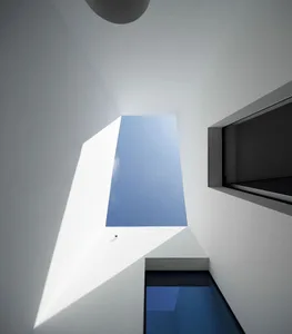 A modern interior with a white courtyard and glass walls.
