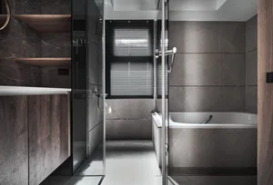 Modern dark bathroom with concrete tiles and a glass shower enclosure.