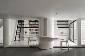 A modern library with a concrete floor and minimalist design, featuring a curved desk and bookshelves.