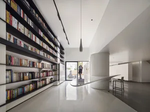 A modern interior design featuring a library with sandblasted concrete shelving.