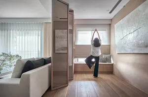 A woman practicing yoga in a modern studio with wooden floors.
