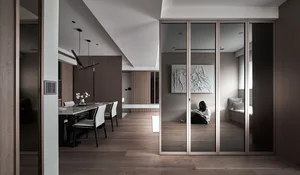 Modern residential interior with wooden flooring, glass walls, and metallic accents