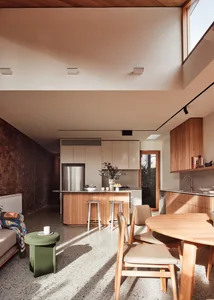A modern residential kitchen featuring minimalist design and wooden surfaces.