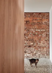 A modern interior with a brick wall and hardwood floor.
